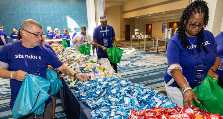 Volunteers assemble backpacks filled with snacks and hygiene supplies to support local women and children experiencing homelessness.