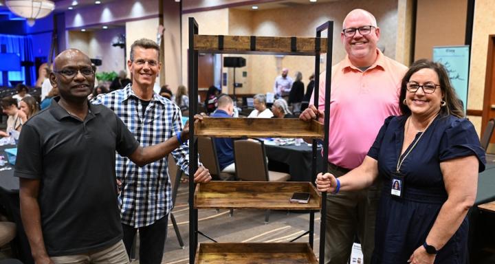 Volunteers work together to build and assemble recreational equipment and activities for children through a community partnership.