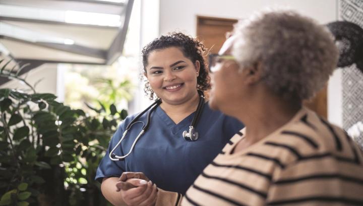 Healthcare professional speaking with an older adult in a community setting.