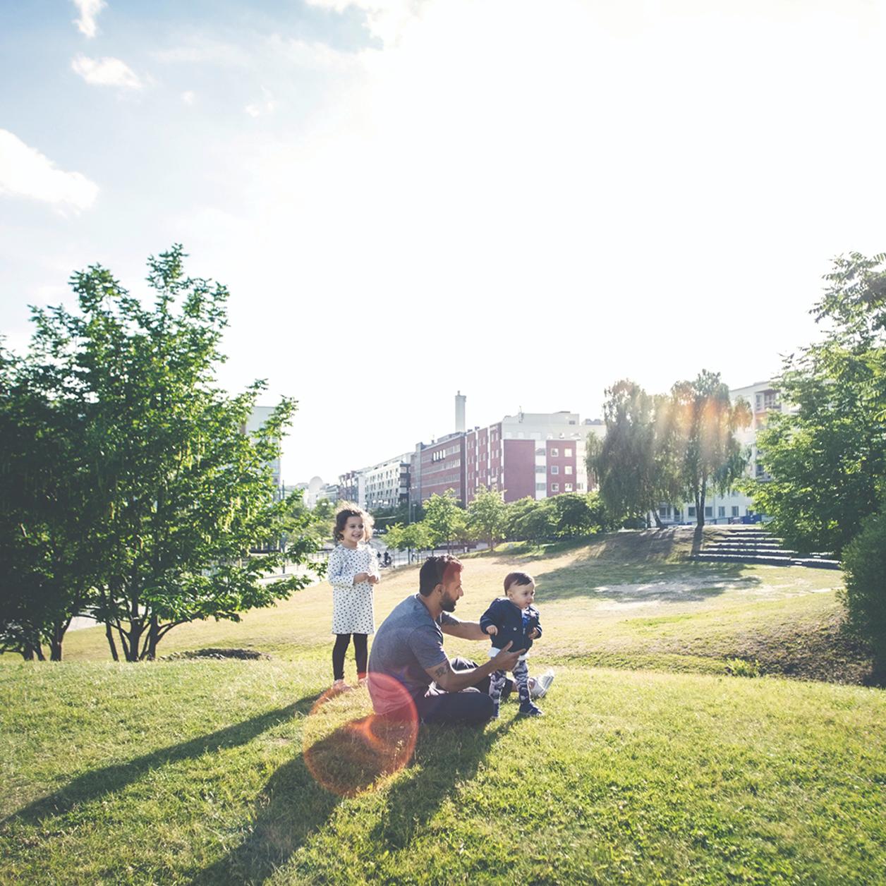 A man playing with his children in a park.